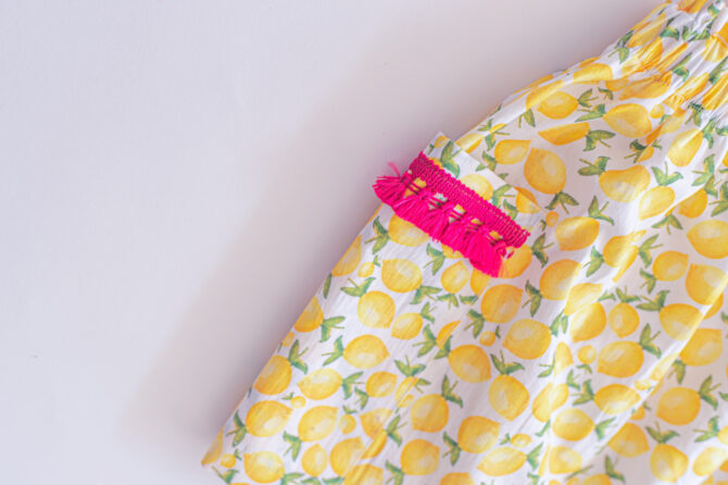 Close up of yellow skirt with pink tassels