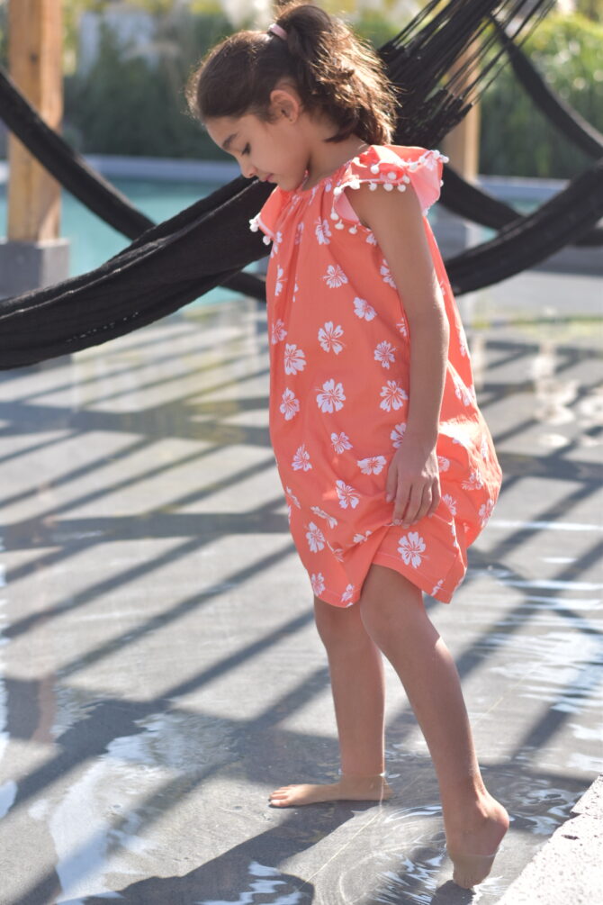 Girl in orange dress by the pool