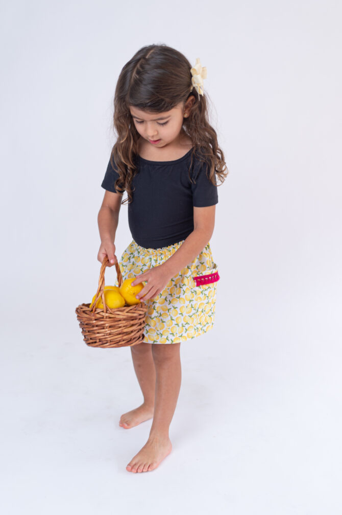 Girl with yellow skirt holding a basket