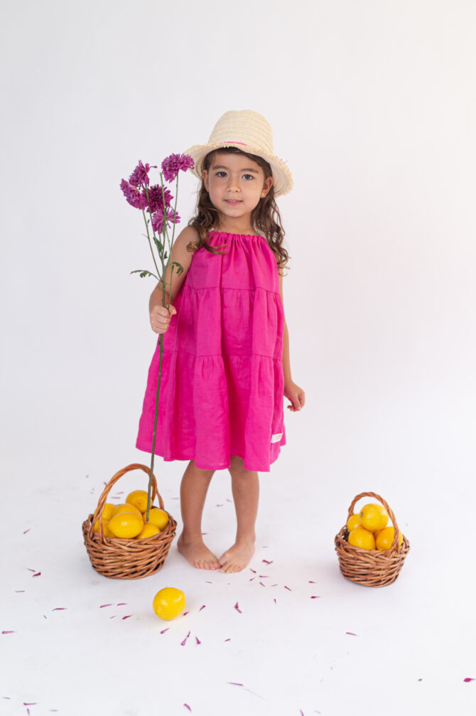 girl in pink linen dress holding flowers