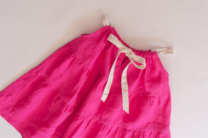 Flatlay pink linen dress showing the backbow
