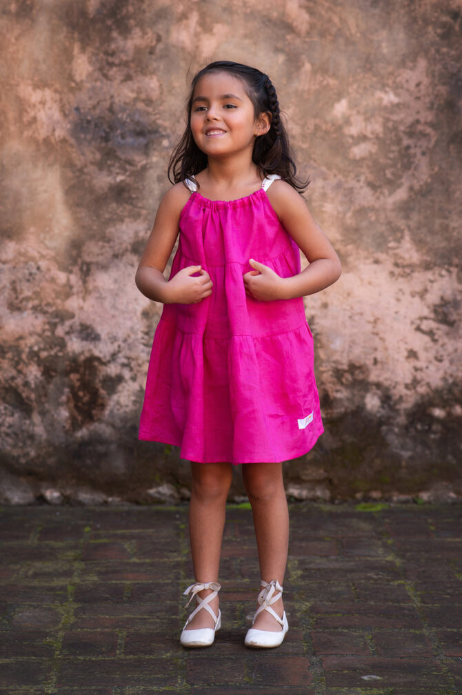 girl in pink linen dress smiling