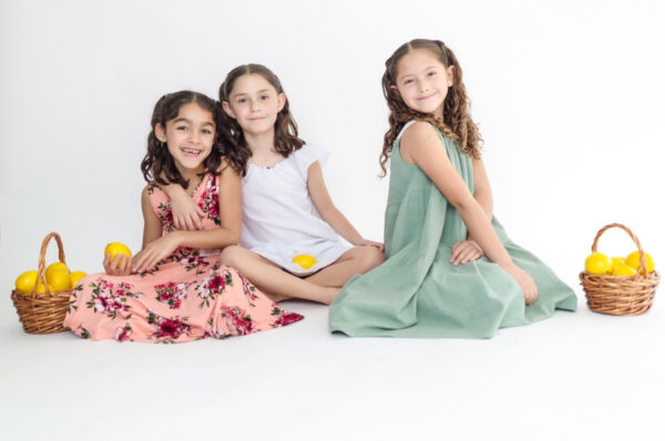 Girls sitting down smiling in their dresses