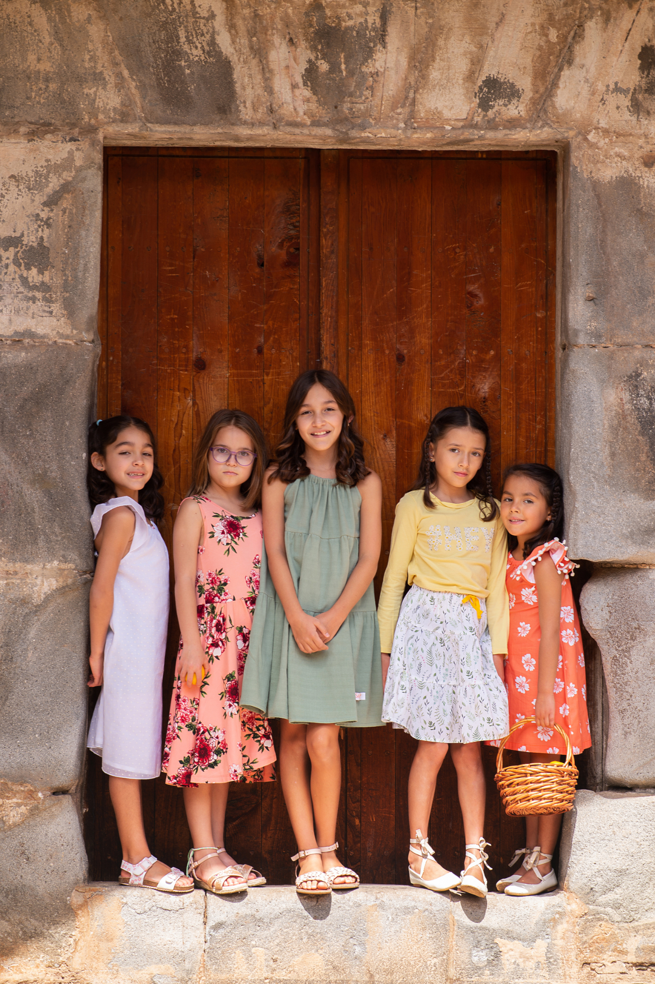 girls standing in front of a large door
